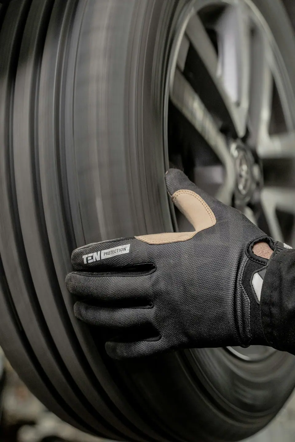 Gloved hand on a car tire (stock photo)